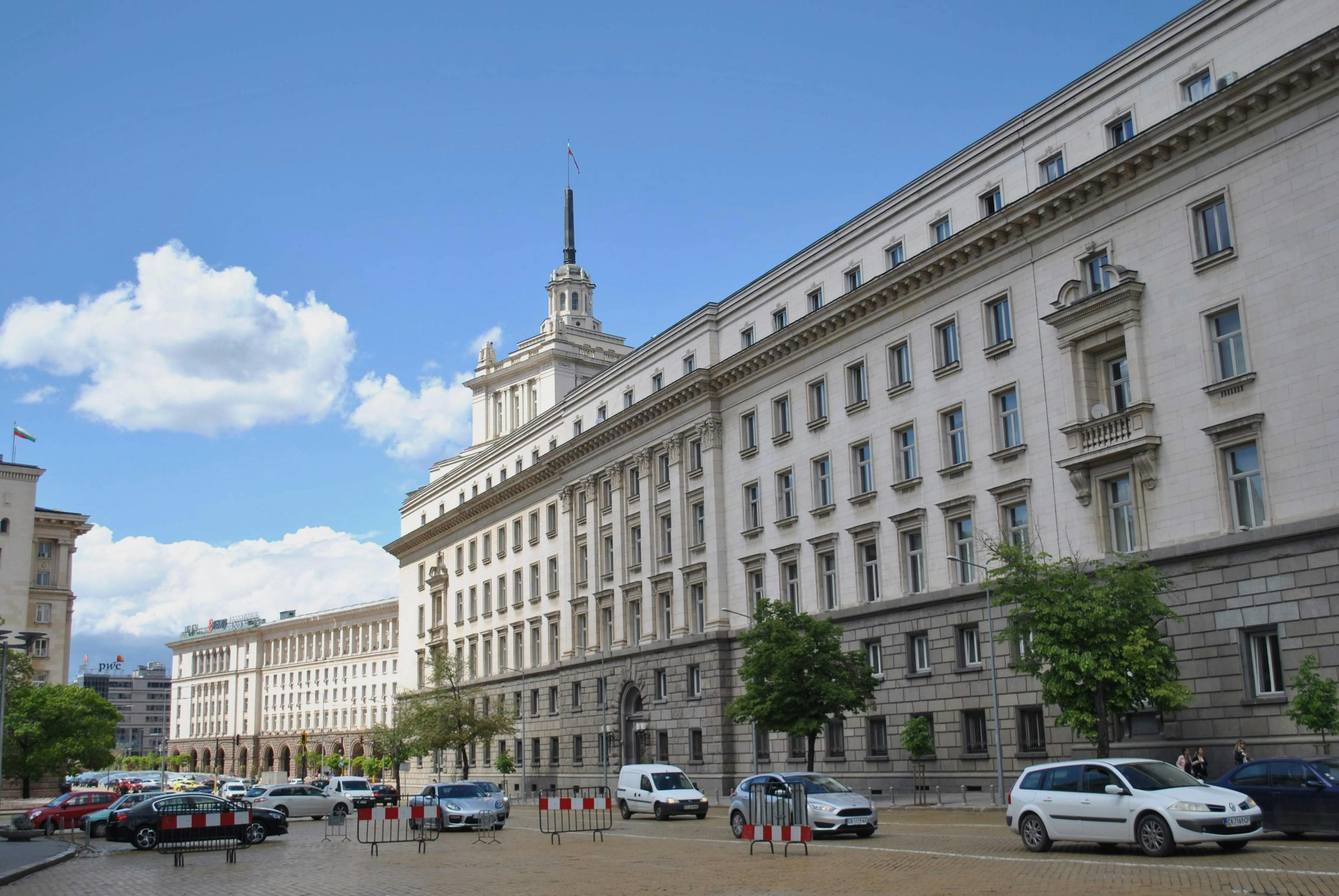 Breathtaking view of a historic government building in Sofia, Bulgaria under a bright blue sky.