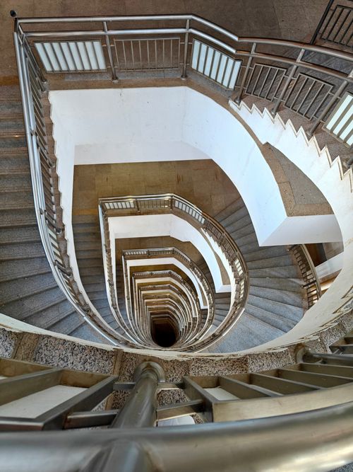 Free Dramatic view of a spiral staircase captured from above showcasing elegant architectural design. Stock Photo