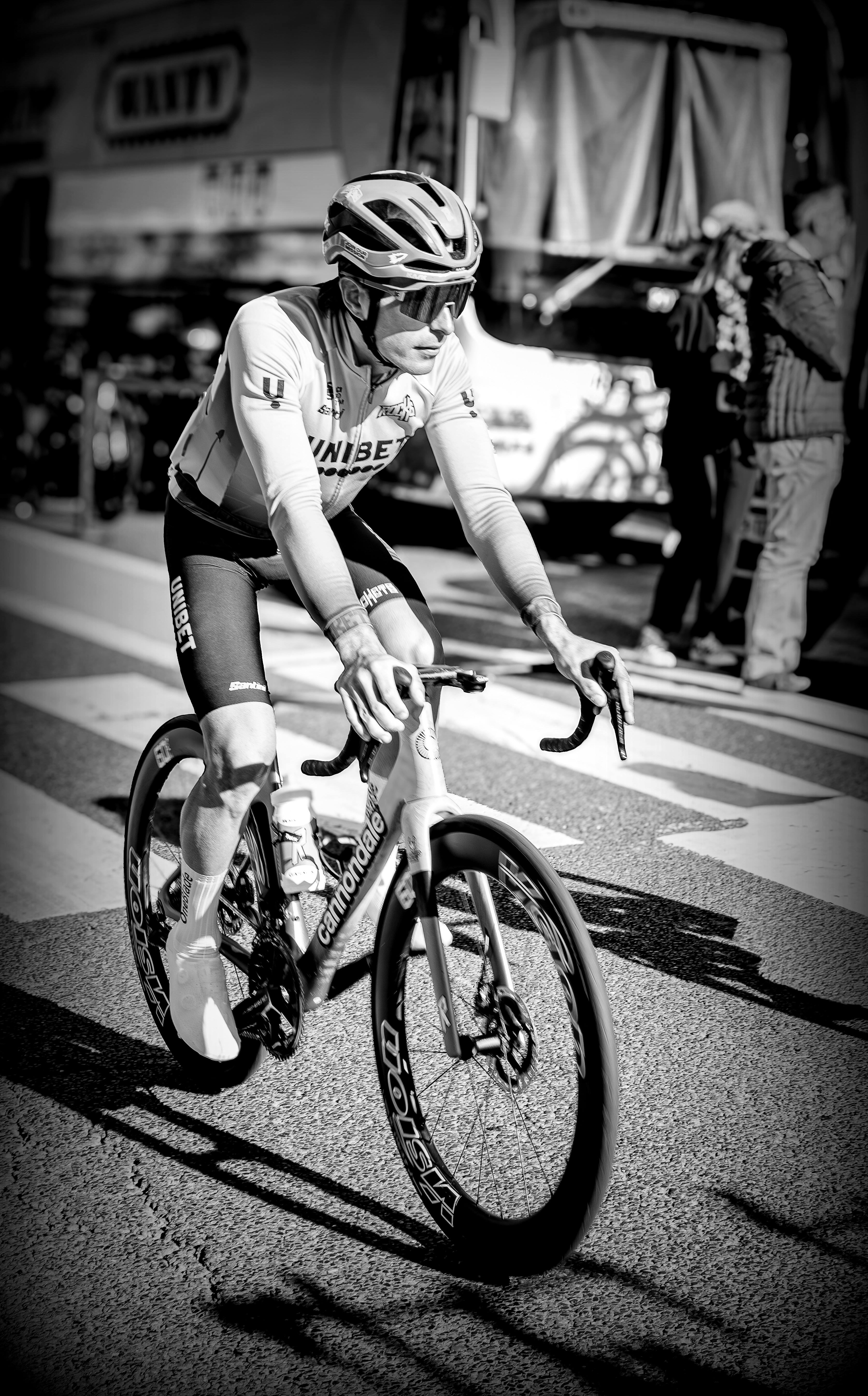 A cyclist in action during a road race, captured in monochrome.