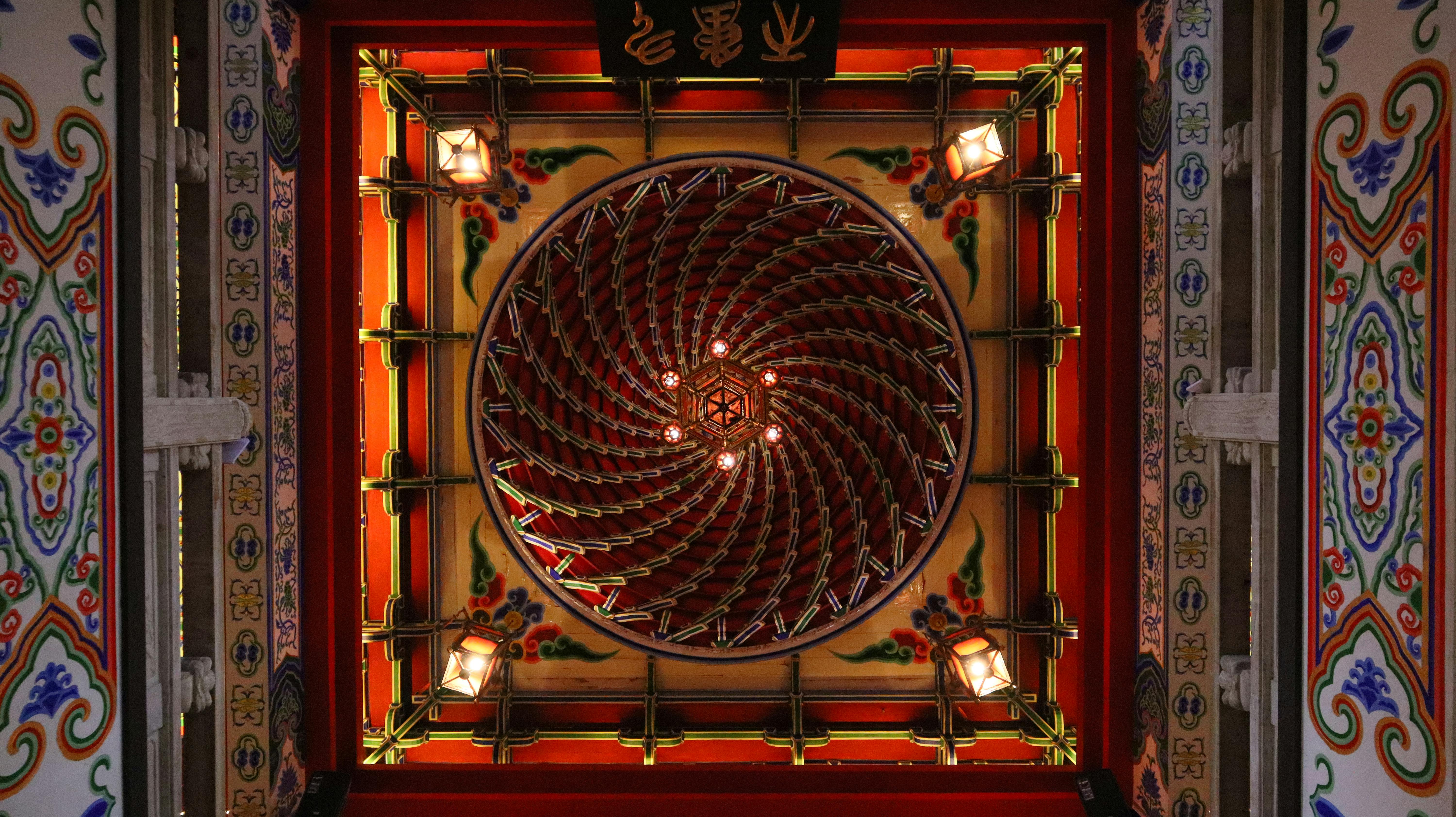 Free Intricate view of a colorful spiral ceiling in a traditional temple, featuring ornate patterns and lanterns. Stock Photo