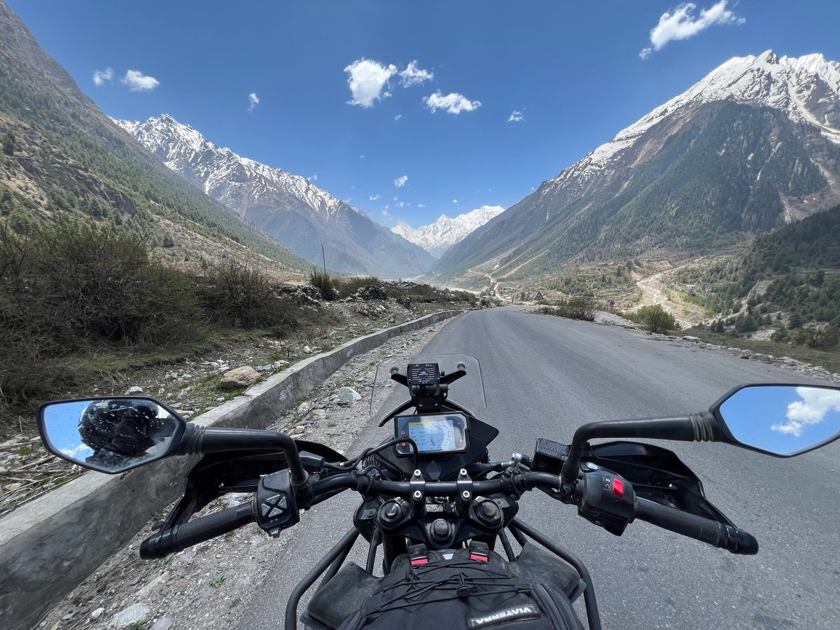 Vedere de pe ghidonul motocicletei spre piscuri inzapezite