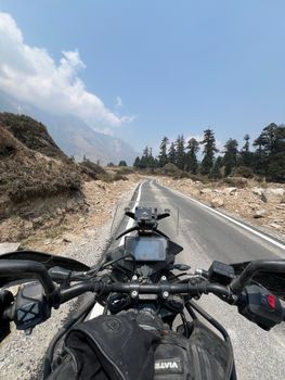 POV motorcycle ride on a scenic mountain road with clear skies.