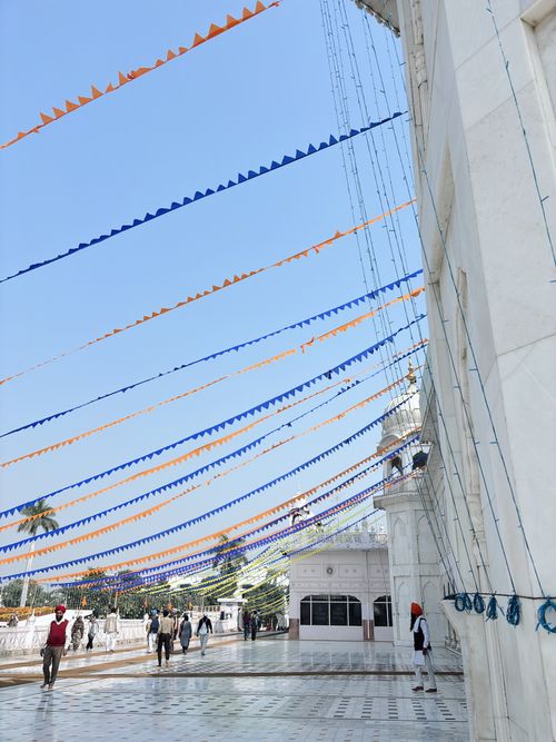 Free Colorful festival decorations at a Gurdwara in Patiala, India, with blue skies and an architectural backdrop. Stock Photo