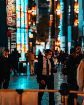 Experience the bustling nightlife in Dotonbori, Osaka with bright neon lights and busy streets.