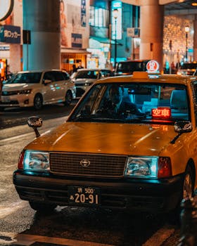 Illuminated taxi on a bustling street in Dotonbori, Osaka. A quintessential Japanese night scene.