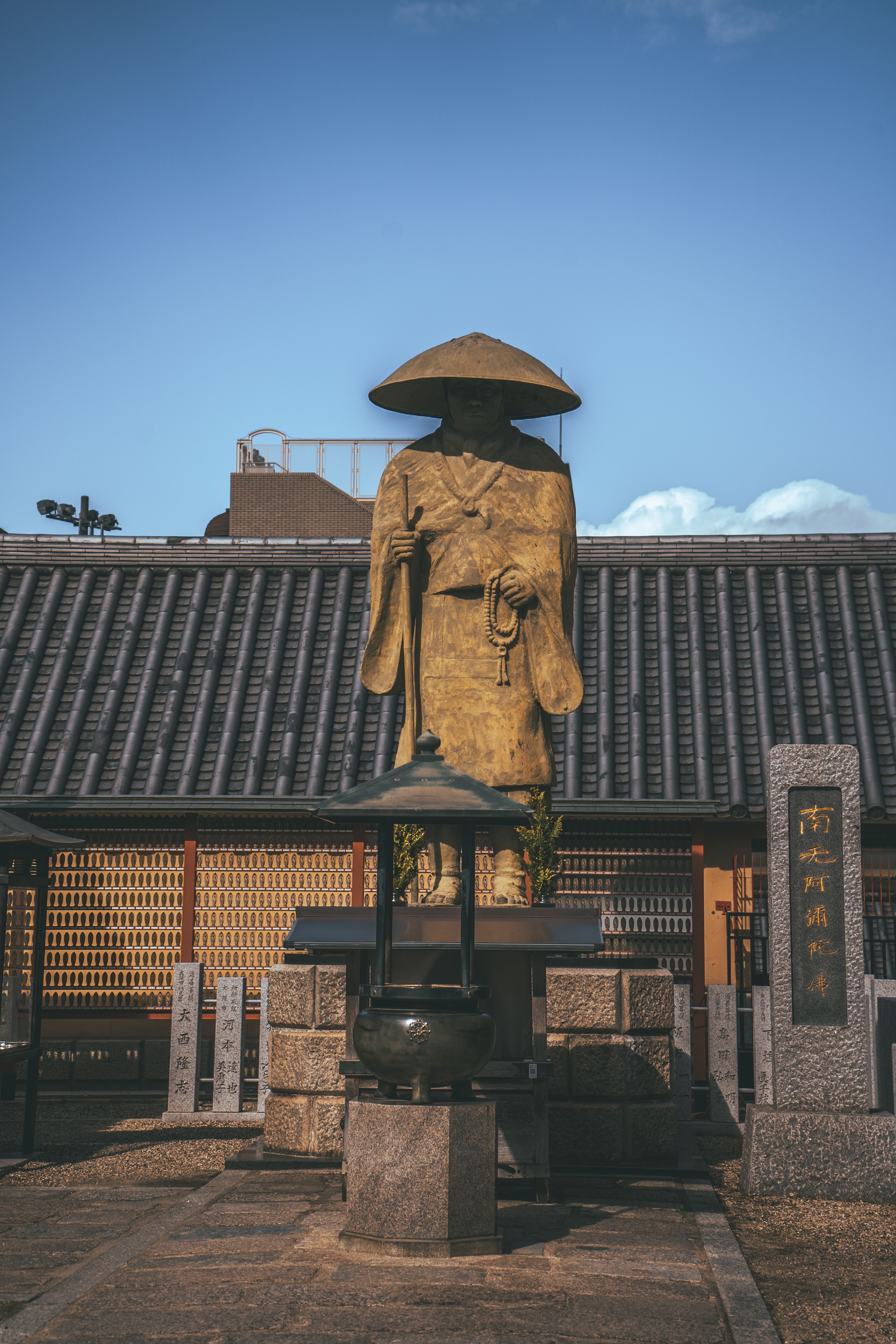 Serene Buddhist statue at Shitennoji Temple in Osaka, Japan, under a clear blue sky.