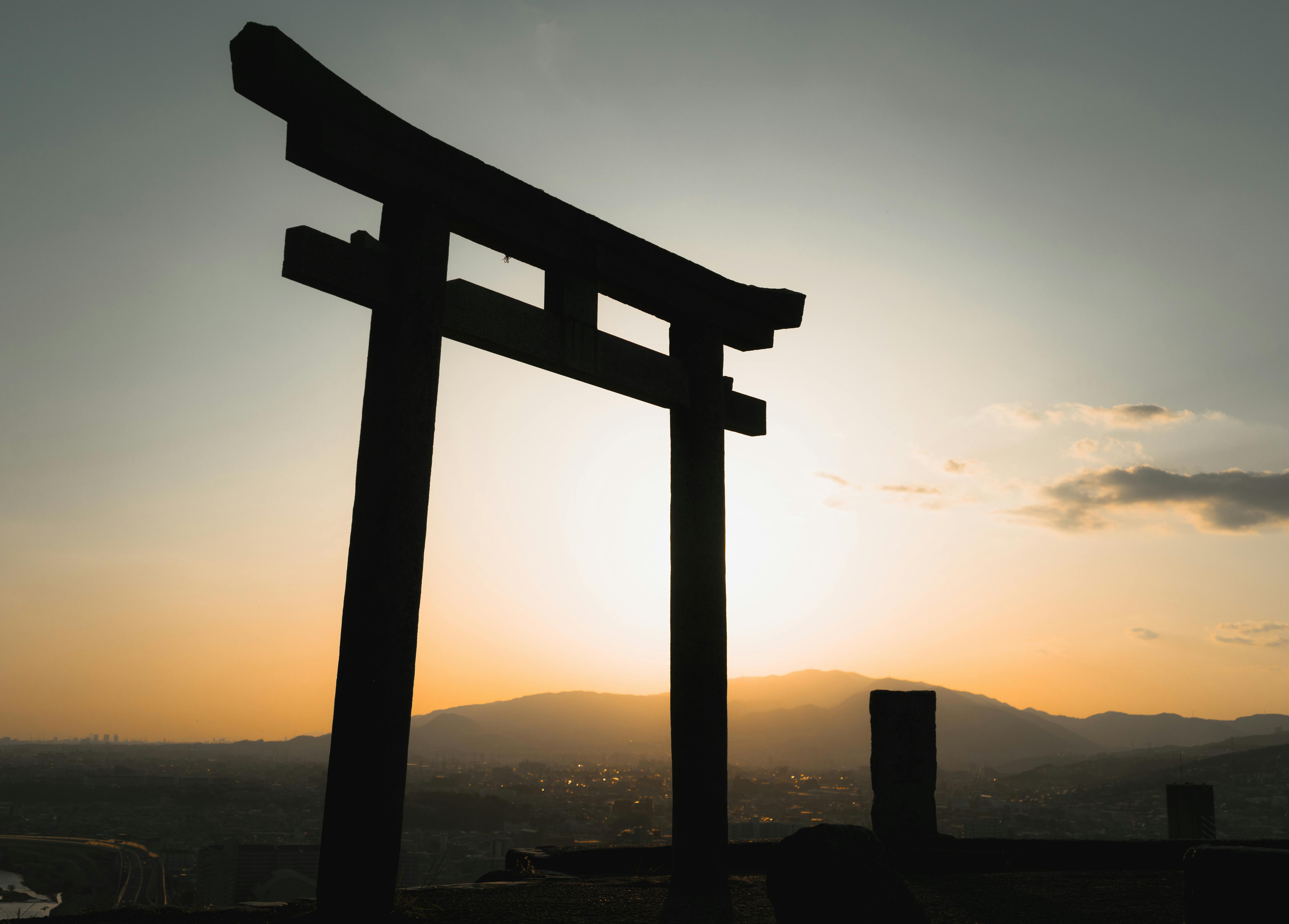 A stunning silhouette of a Torii gate against a colorful sunset sky in Ikeda, Japan.
