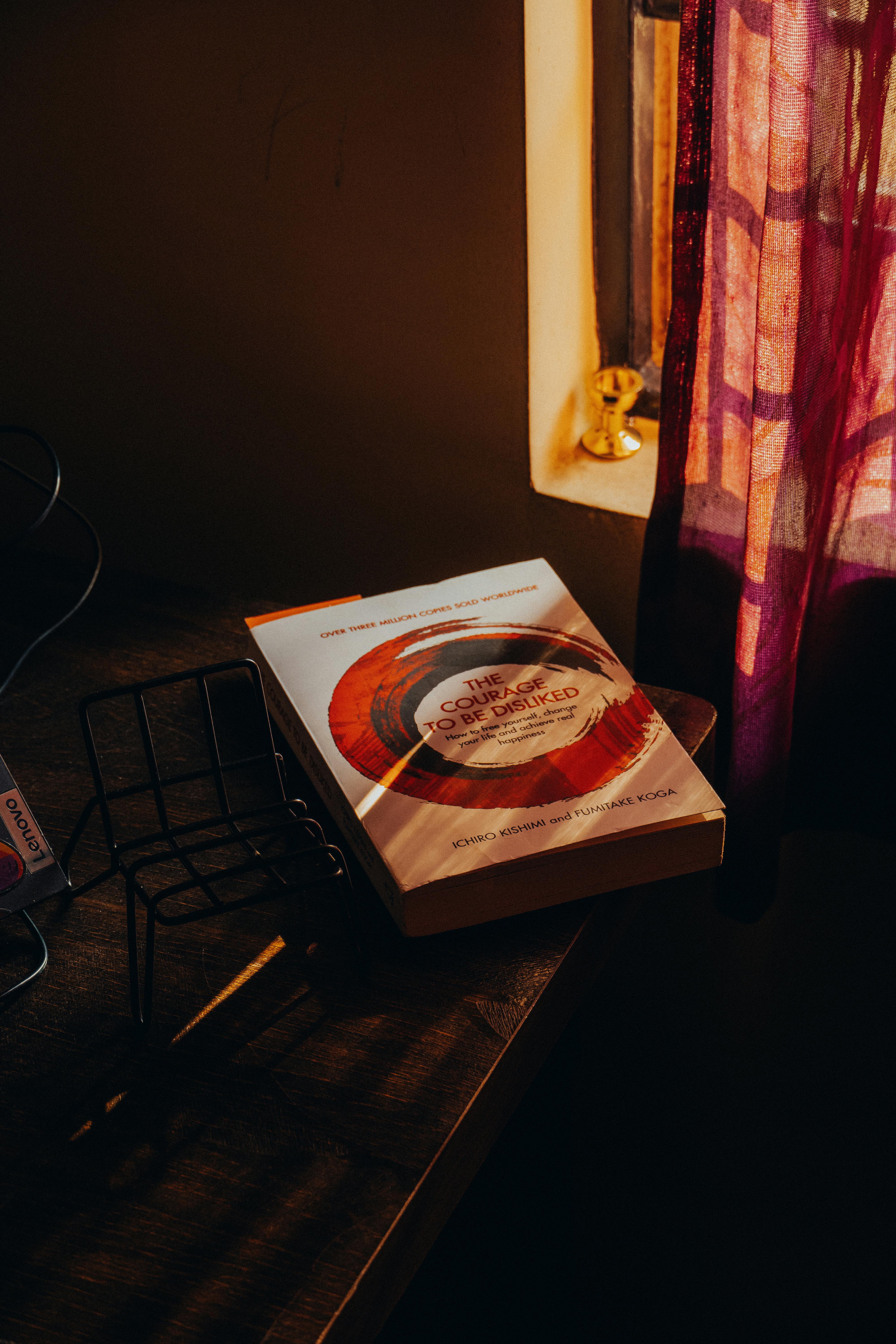 gratis Een gezellig hoekje in de kamer met een boek op tafel, badend in warm, intiem zonlicht. Stockfoto