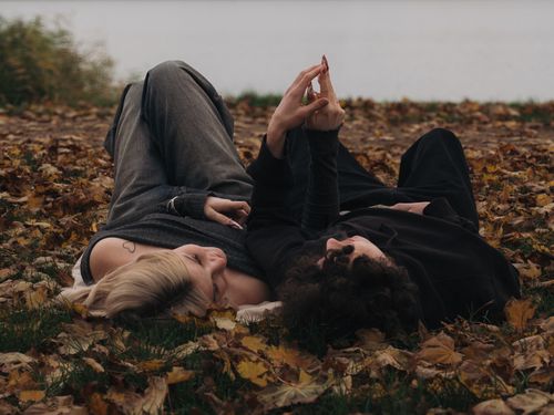 Free Young couple lying on fallen leaves in autumn, enjoying a peaceful moment outdoors. Stock Photo