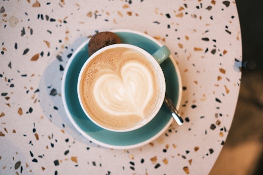 Top view of a latte with heart art on a terrazzo table, perfect for lifestyle and coffee enthusiasts.
