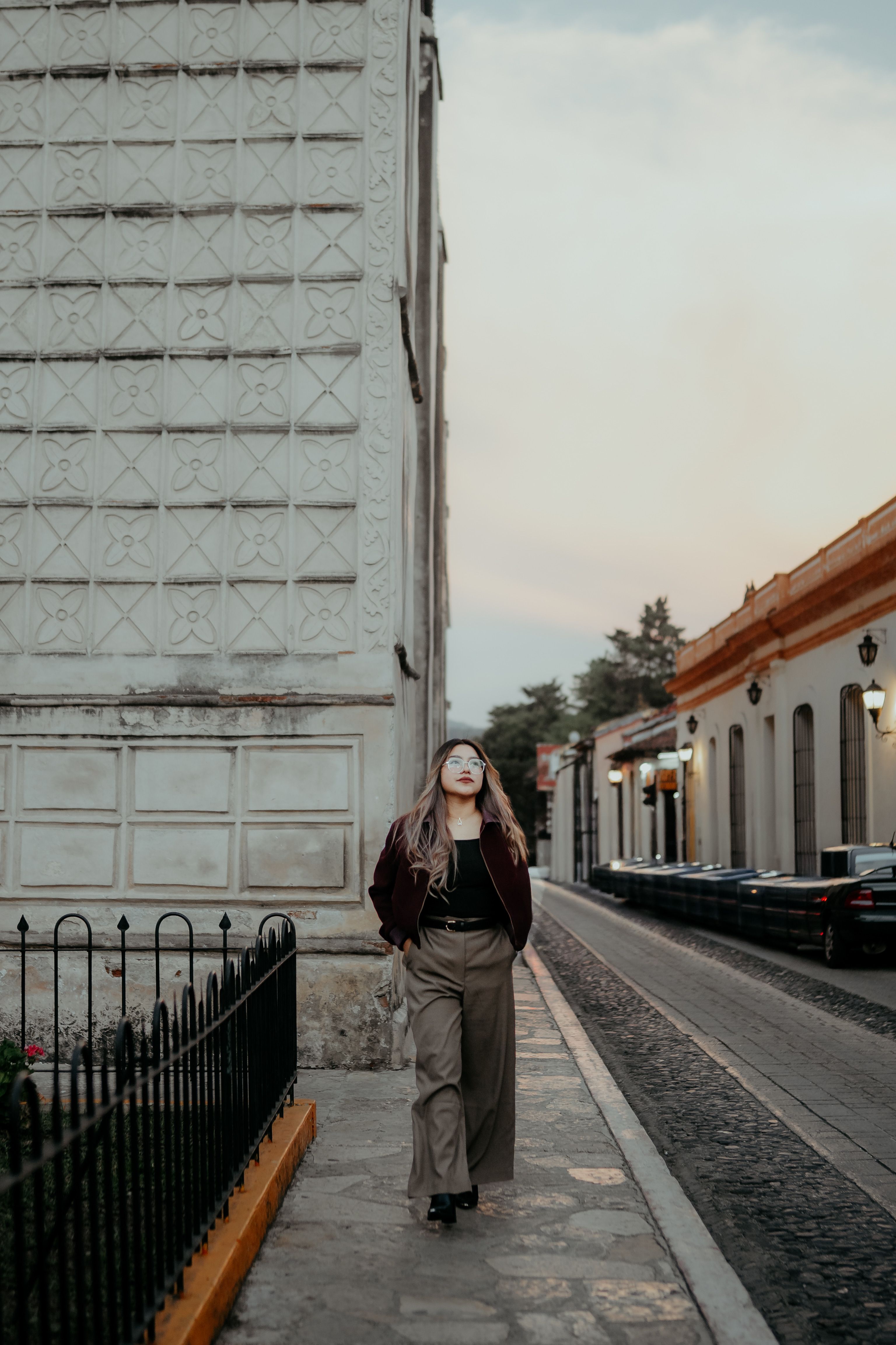 A woman walks down a charming street in San Cristóbal de las Casas, capturing local architecture.