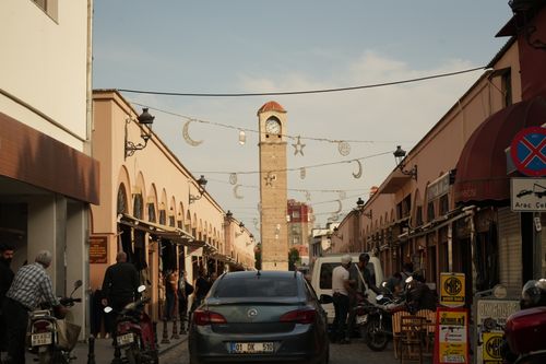 Free Vibrant marketplace street scene featuring a prominent clock tower and bustling activity. Stock Photo