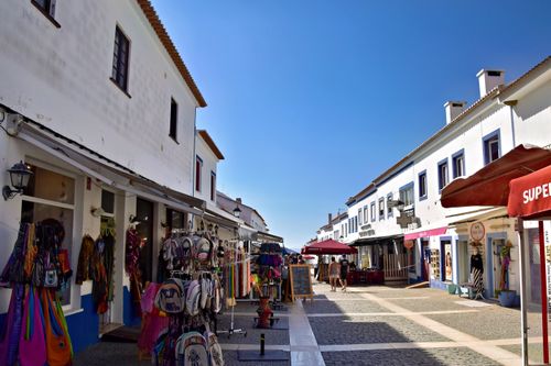Free Colorful market street in Setubal, Portugal bustling with local shops and vibrant summer atmosphere. Stock Photo