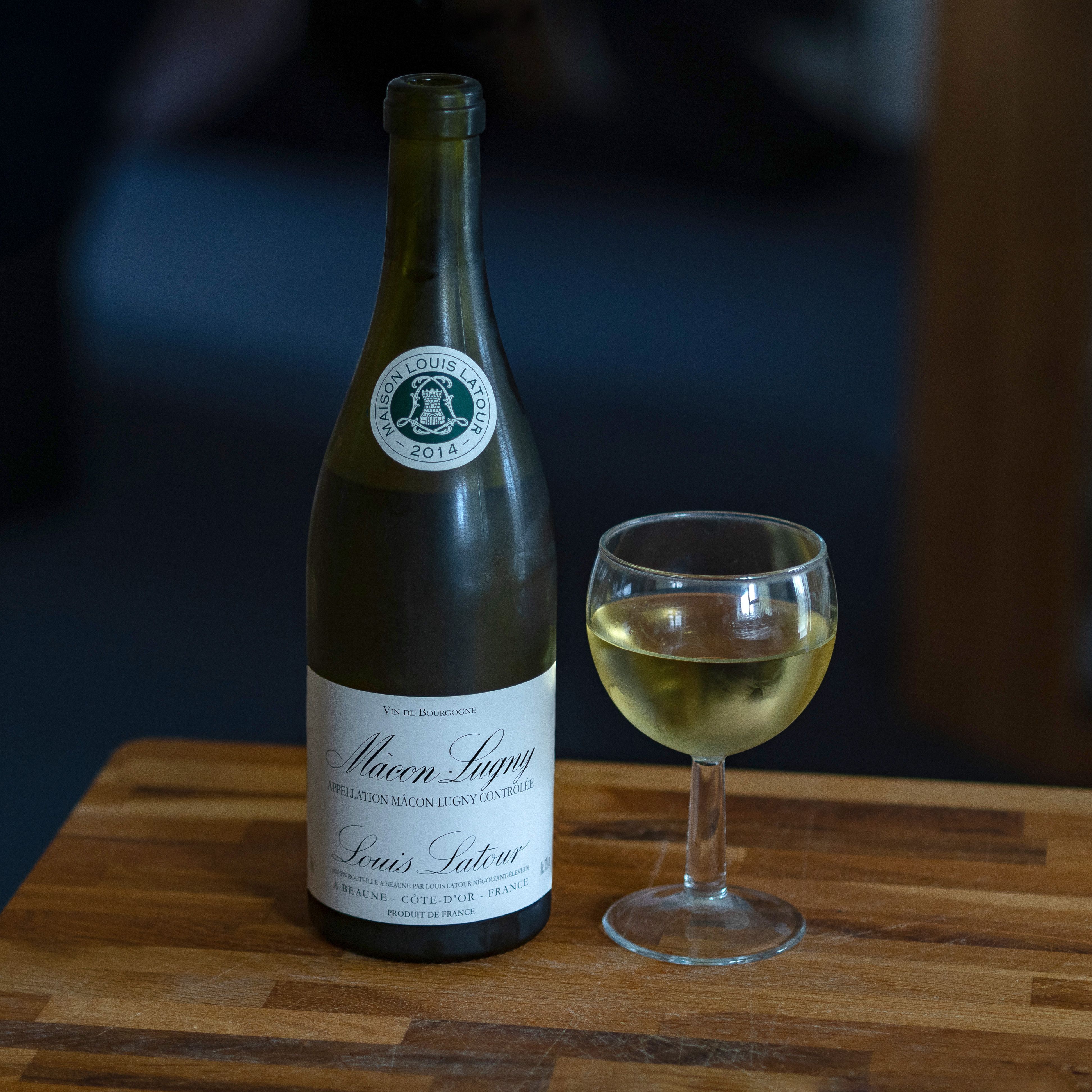 bartender pouring natural wine from a bottle into a glass
