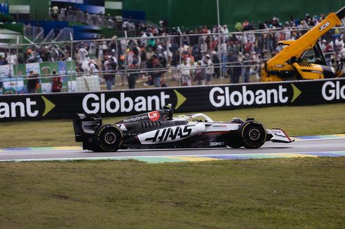 Free Haas Formula 1 car speeding on the Interlagos Circuit in São Paulo, Brazil with spectators in the background. Stock Photo
