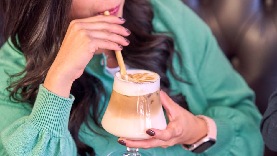 person drinking coffee with a straw to prevent stains person drinking coffee with a straw to prevent stains