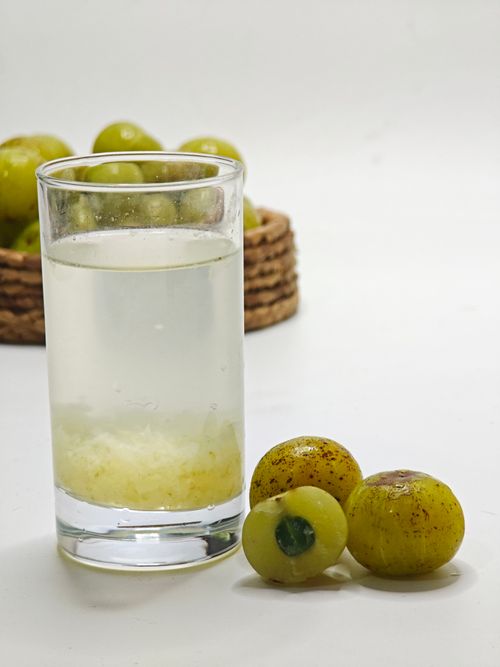 Free Glass of amla juice beside fresh gooseberries, showcasing a healthy drink choice. Stock Photo