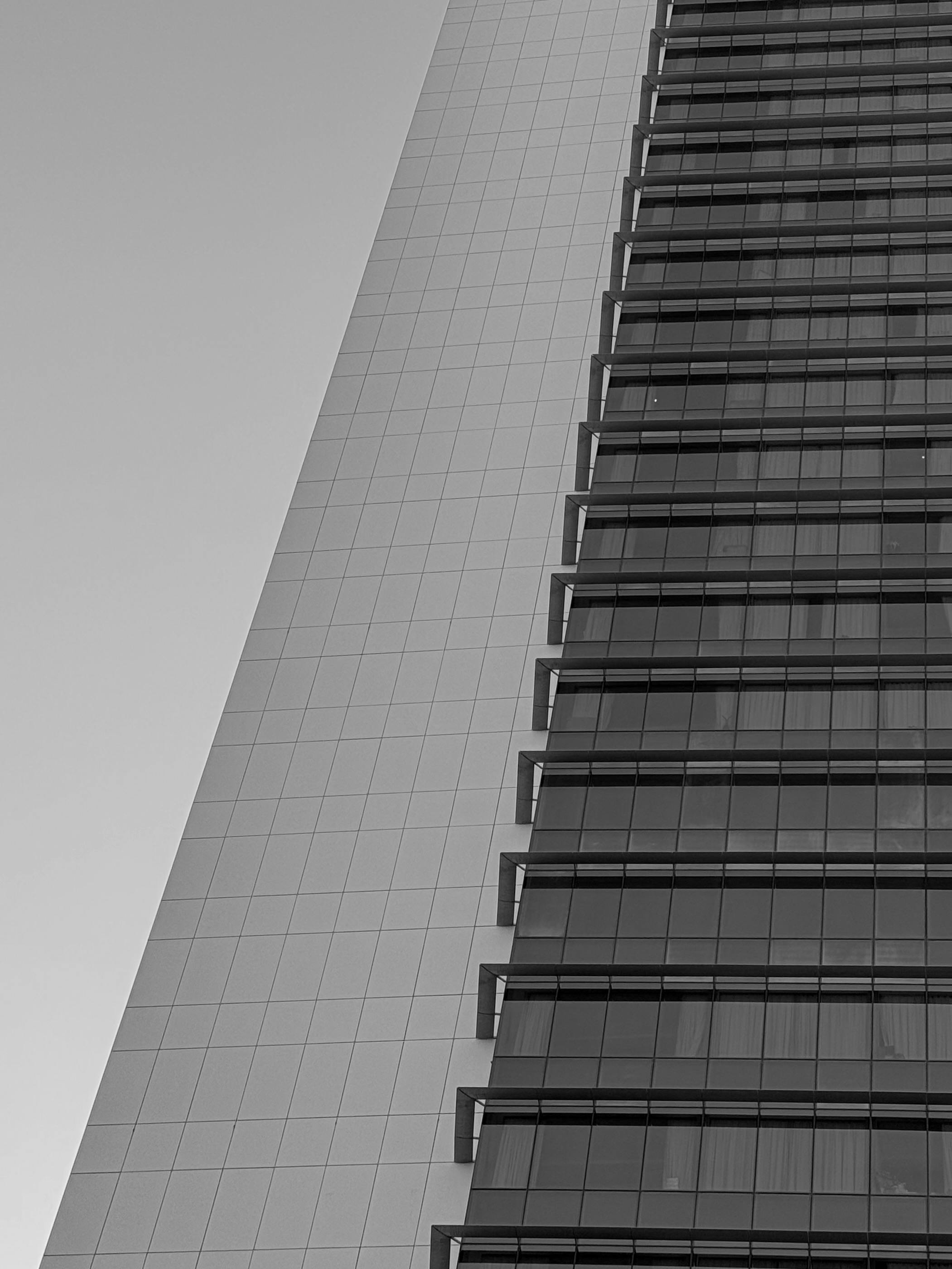 Kostenlos Abstrakte Schwarz-Weiß-Ansicht der Fassade eines Wolkenkratzers in Dubai, die modernes architektonisches Design zeigt. Stock-Foto