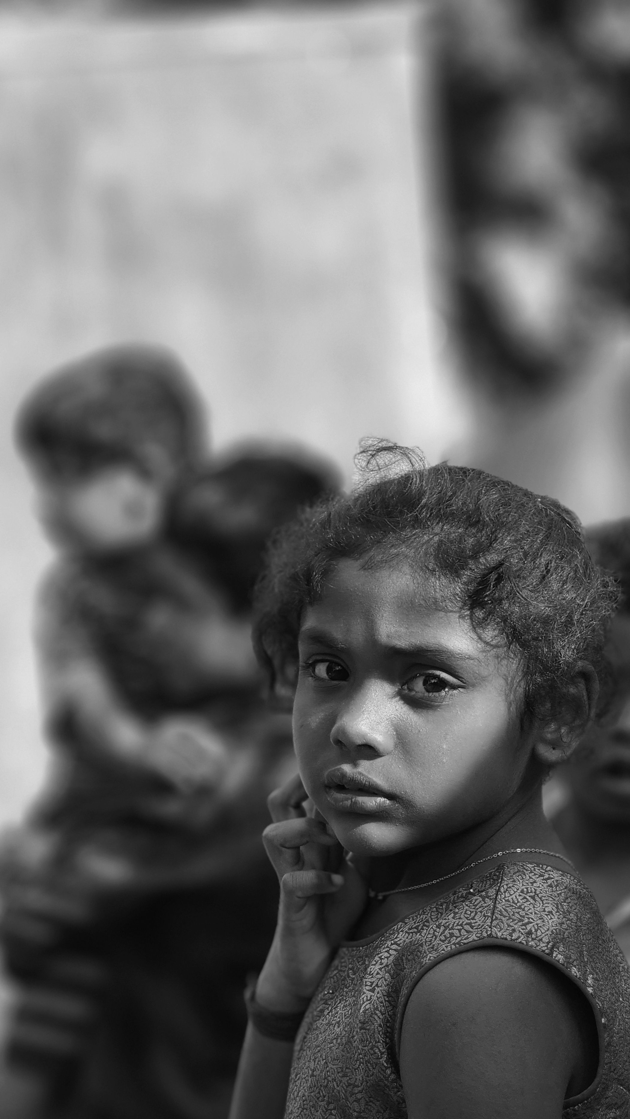 Black and white portrait of a thoughtful young girl looking back, capturing deep emotions.