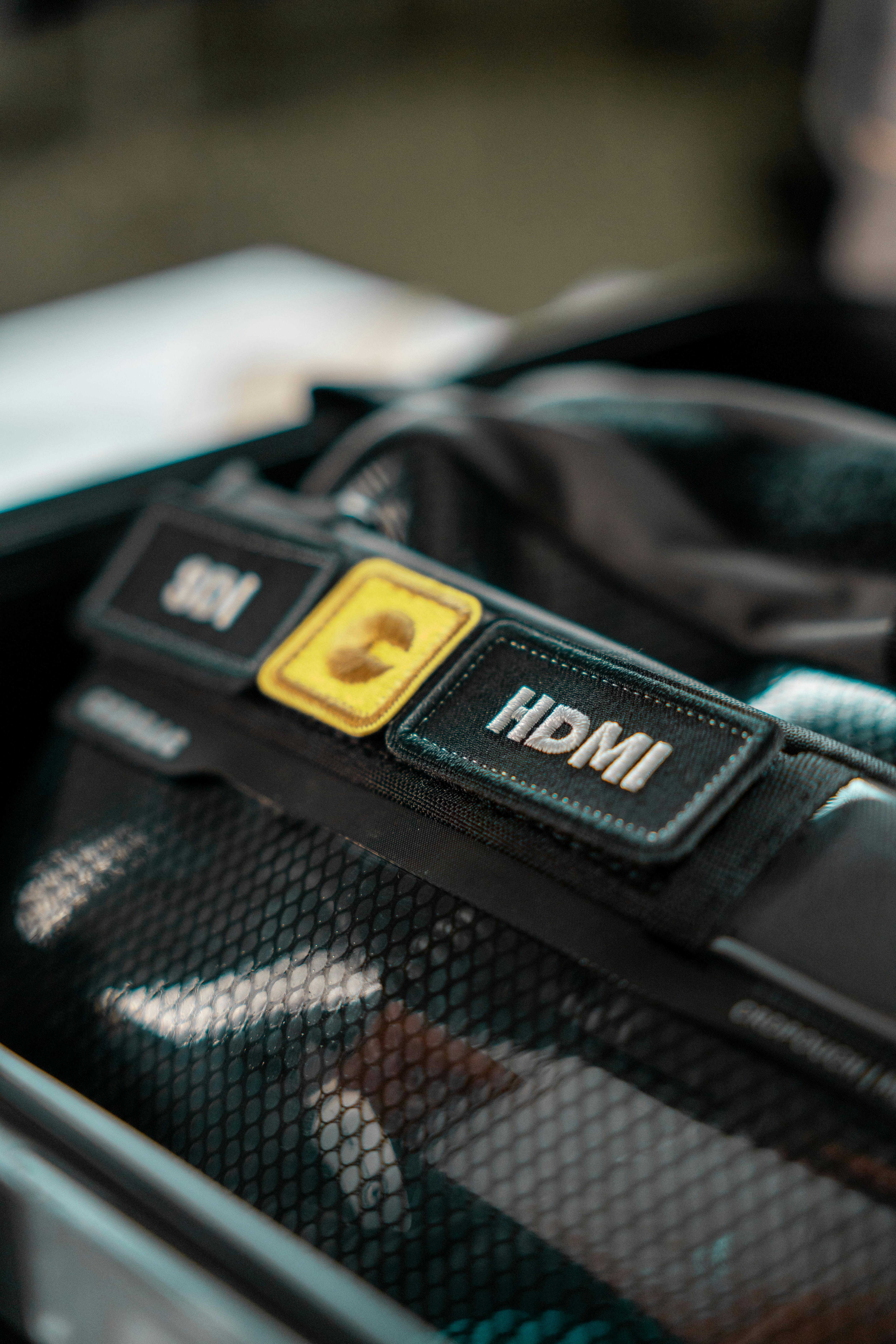 Detailed view of HDMI cable organizer with netting and labels in a storage case.