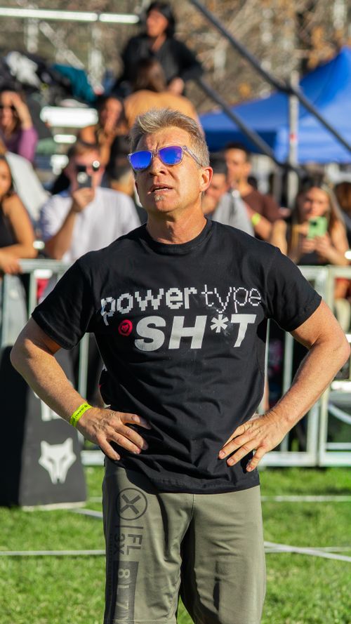 Free Man wearing sunglasses and a graphic T-shirt at a lively outdoor event. Stock Photo