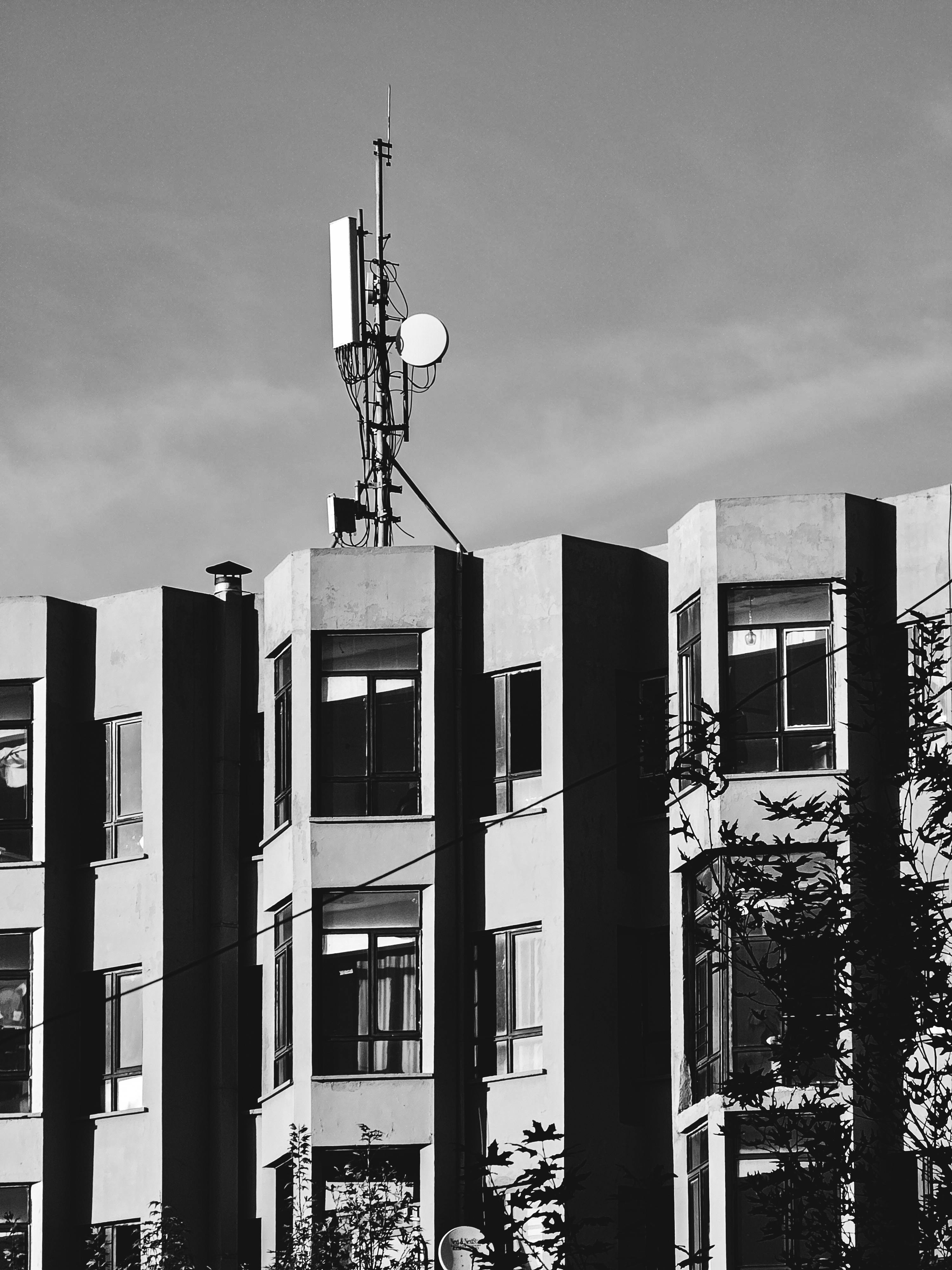 De franc Un edifici urbà modern amb una antena de comunicació monocromàtica. Foto d'estoc