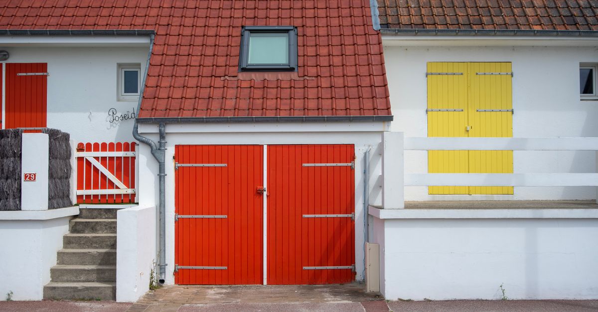 Brightly colored house facade featuring red and yellow doors and a red tiled roof.