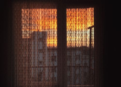 Free Beautiful sunset view through a lace curtain creates a warm and cozy atmosphere. Stock Photo