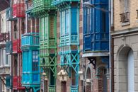 Vibrant architectural facades in Mers-les-Bains featuring ornate balconies and painted woodwork.