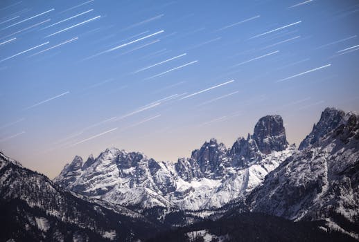 Star trails create a stunning effect over the snowy peaks of the Dolomites at night.