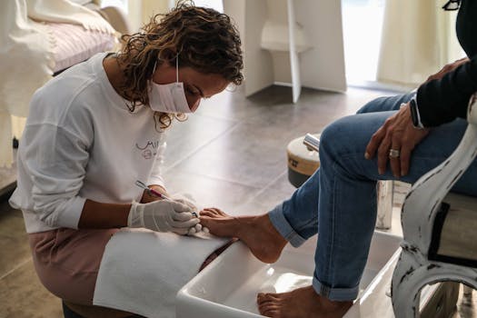 A beauty technician performs a pedicure, providing professional foot care at a salon.