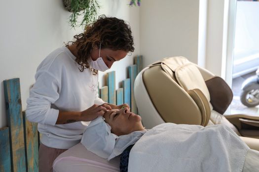 Woman receives calming facial treatment at a spa, enhancing relaxation and self-care.