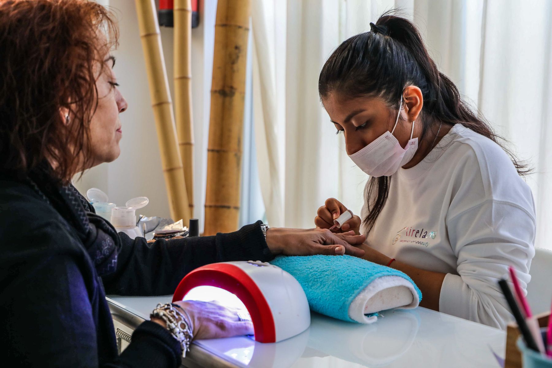 Nail technician providing a careful manicure service