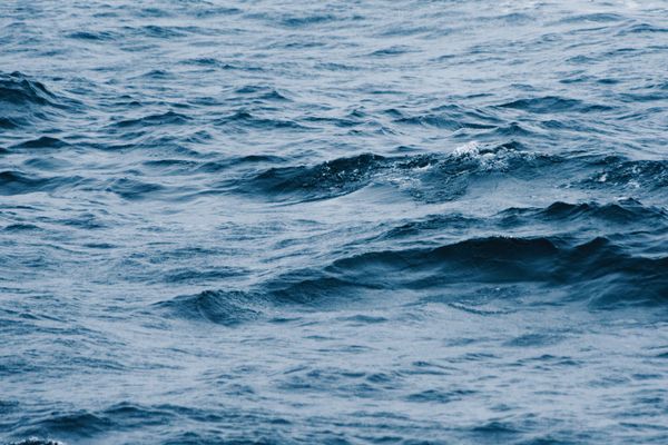 A detailed view of vibrant blue ocean waves creating an abstract aquatic texture, ideal for backgrounds