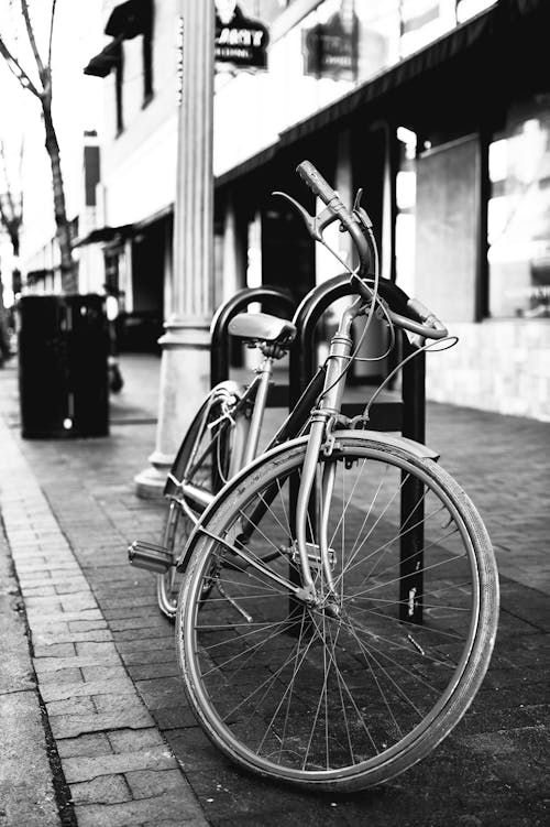 歩道に駐車した自転車のグレースケール写真