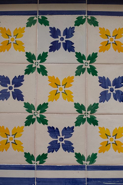 Free Close-up of vibrant Portuguese azulejos tiles featuring blue, yellow, and green floral motifs. Stock Photo
