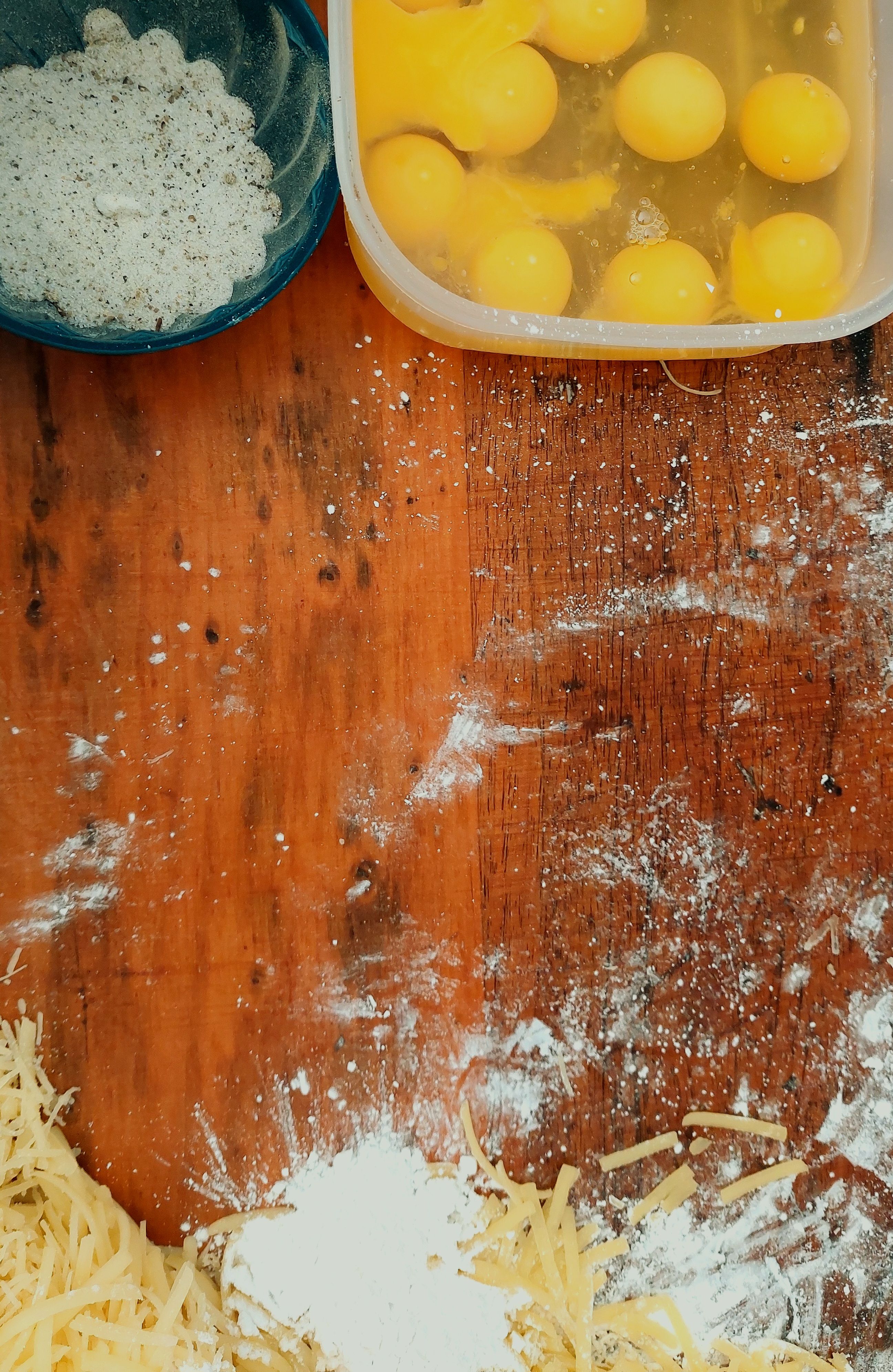Flat lay of raw dog treat ingredients chickpea flour cricket powder flaxseeds and eggs on a wooden surface