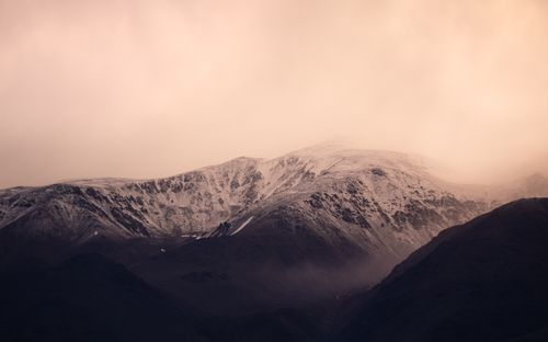 Free Stunning view of snow-capped Andes mountains in Potrerillos, Mendoza at sunset, shrouded in haze. Stock Photo