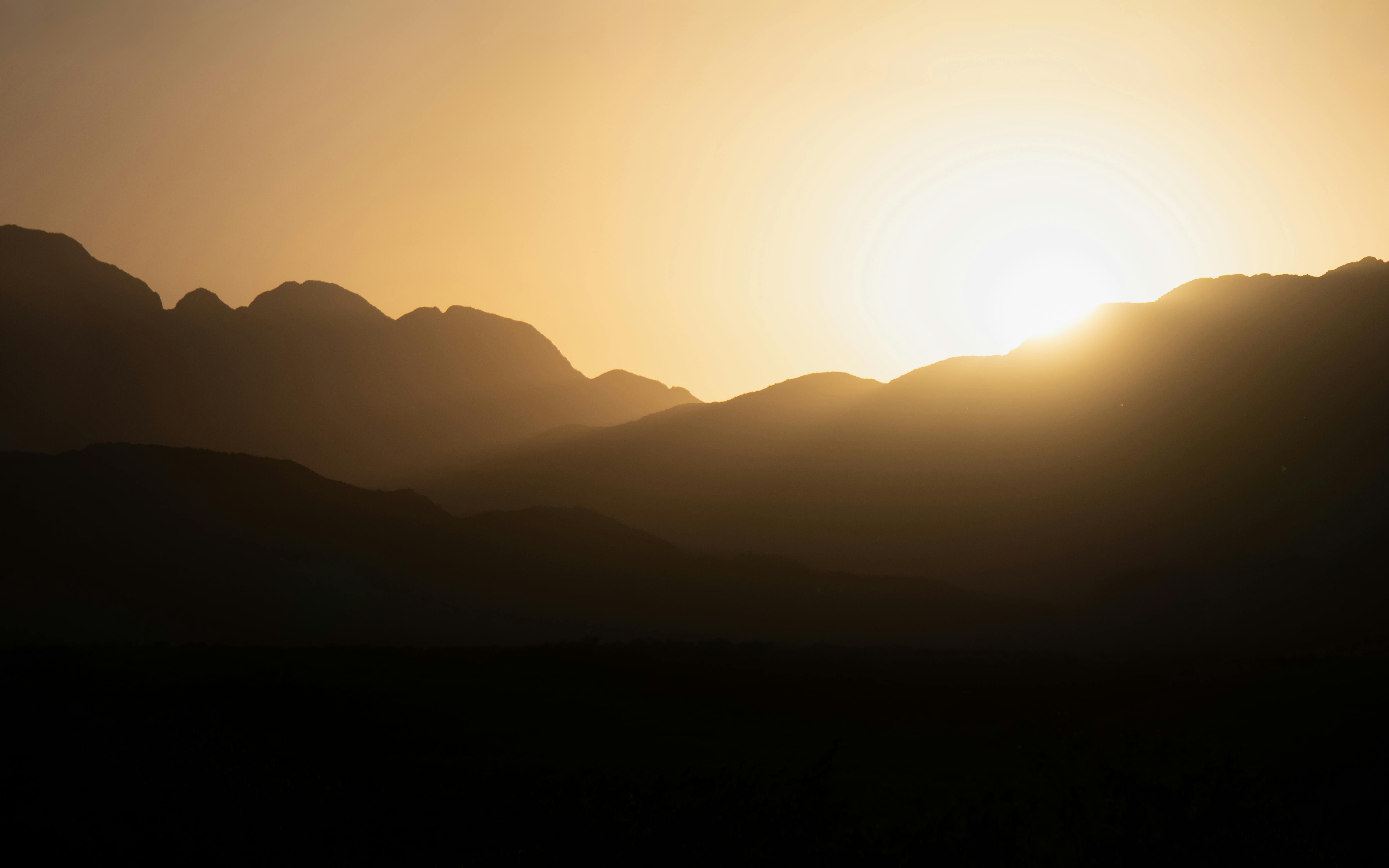 Beautiful sunrise illuminating the Potrerillos mountains in Mendoza, Argentina, creating a serene silhouette.