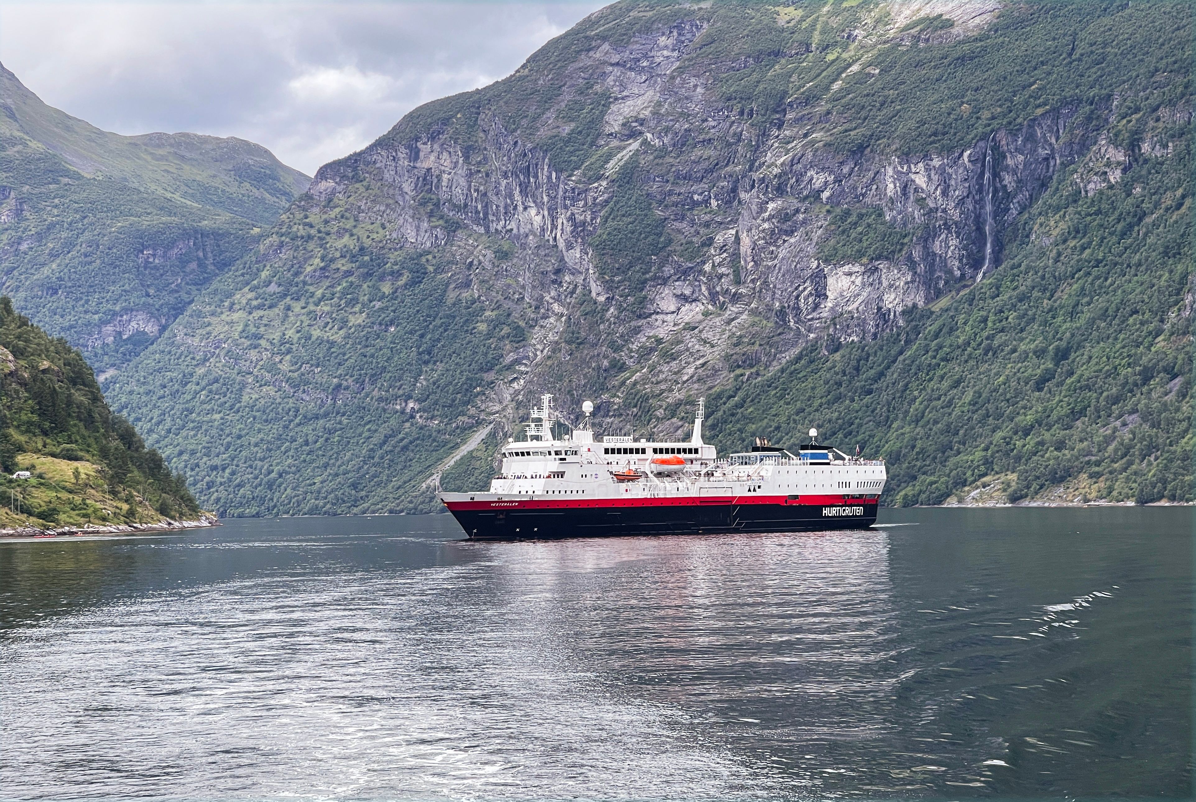 Historic Flåm Railway train winding through a lush Norwegian fjord valley