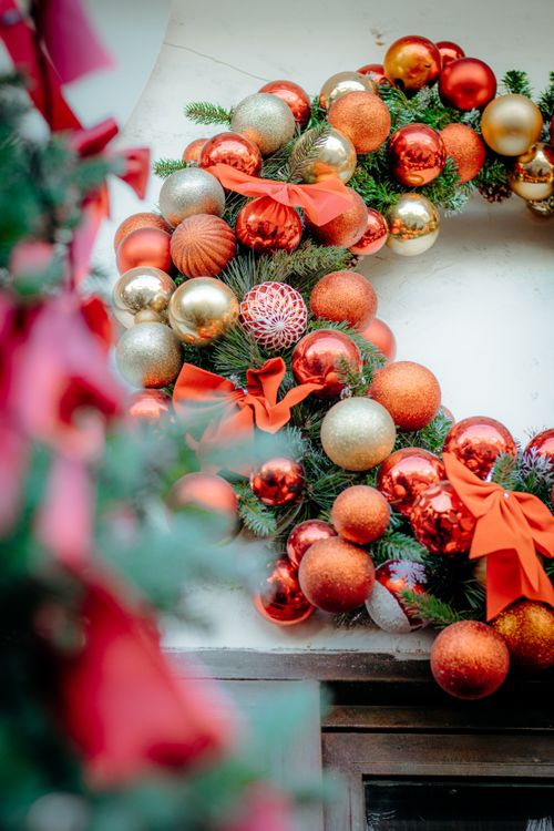 Free Vibrant Christmas wreath adorned with red and gold baubles and ribbons. Stock Photo