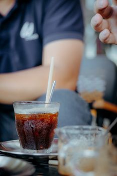 Close-up of iced coffee in glass served in cafe setting. Relaxing atmosphere.