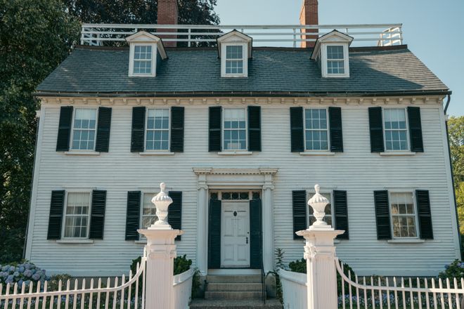 Colonial-style clapboard house with black shutters and a picket fence — photo by Banx Photography on Pexels