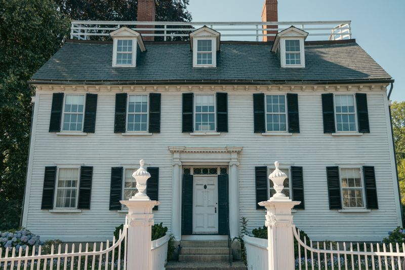 Colonial-style home with black shutters and a white picket fence in Salem, Massachusetts