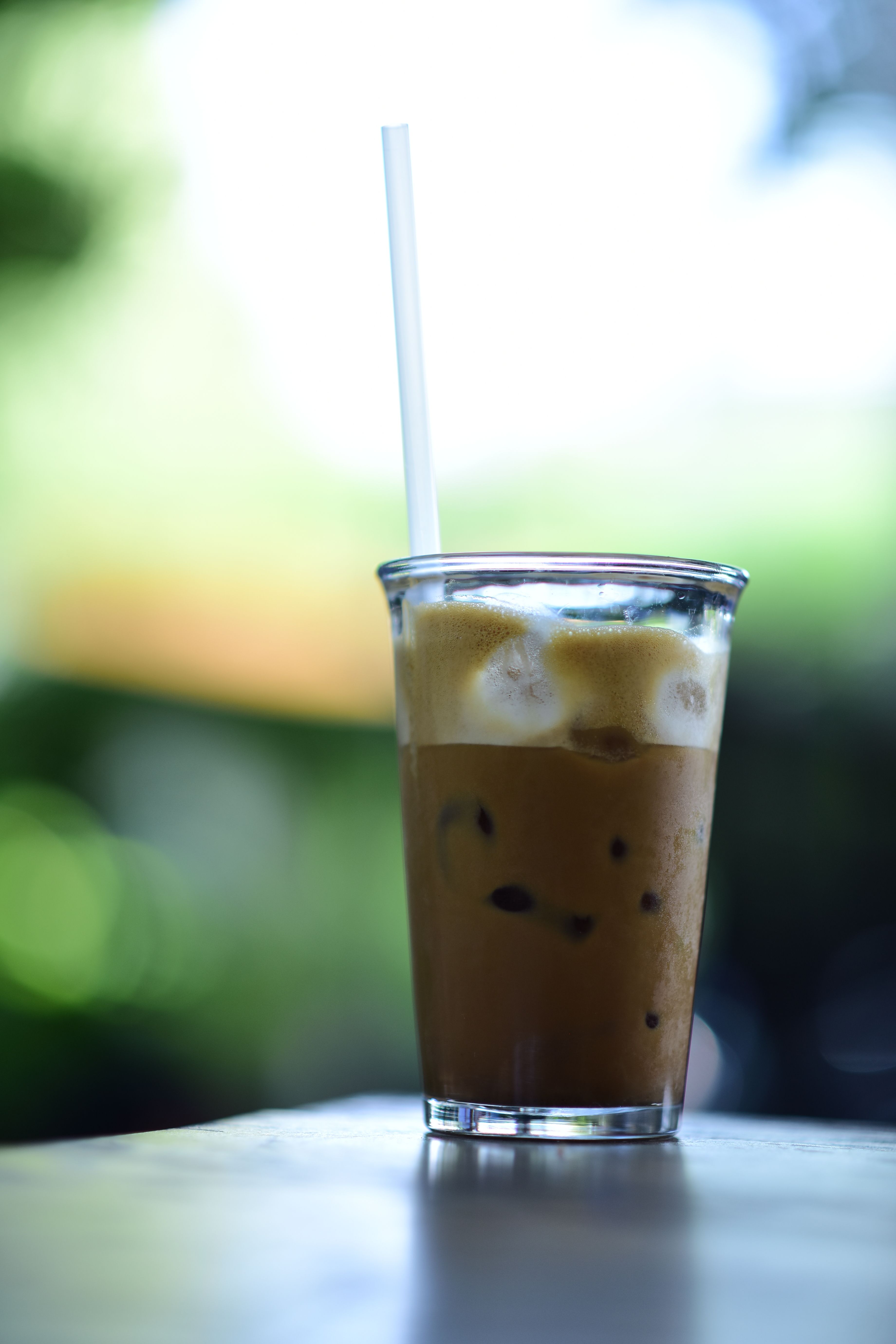 Chilled iced coffee in clear glass with straw, perfect for a summer day.