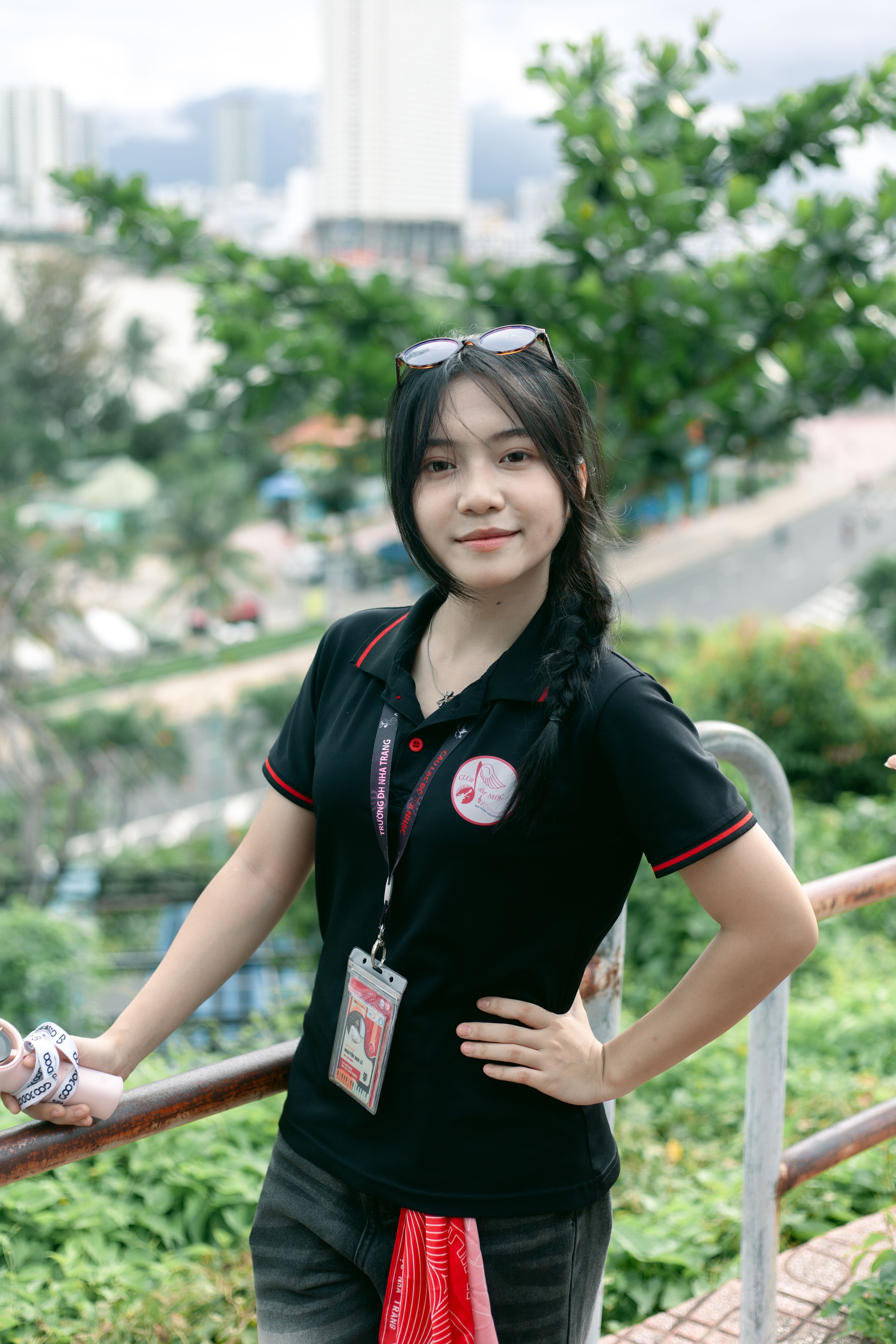 Smiling woman outdoors in an urban area, exuding confidence and style.