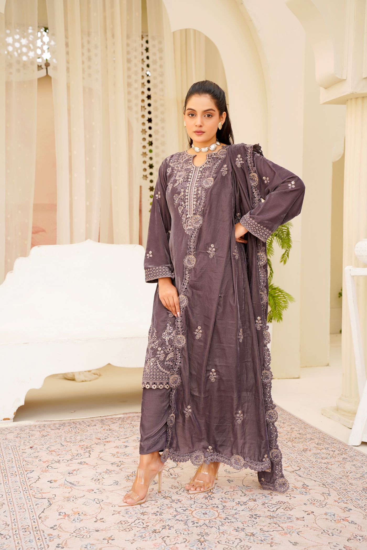 Model wearing a purple embroidered Pakistani suit in an elegant interior