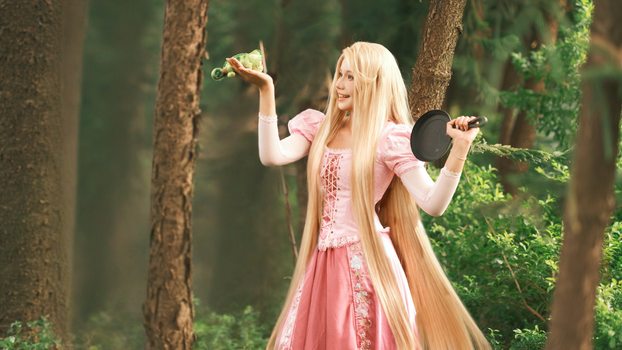Cosplayer dressed as a fairy tale character in a lush green forest.