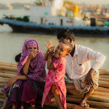 A joyful family enjoying a sunny day by the river in Chittagong, Bangladesh.