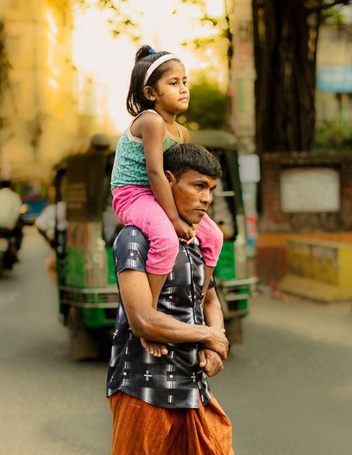 Free A father carries his daughter on his shoulders in a busy street of Chittagong, Bangladesh. Stock Photo